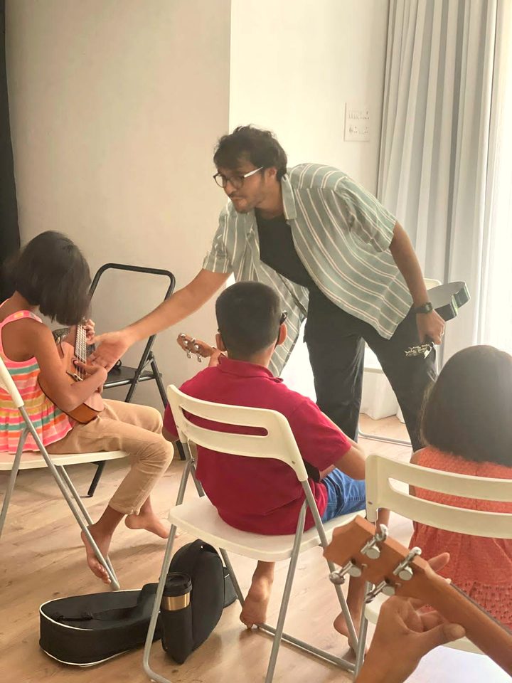 A child learning guitar one-to-one with Akshit